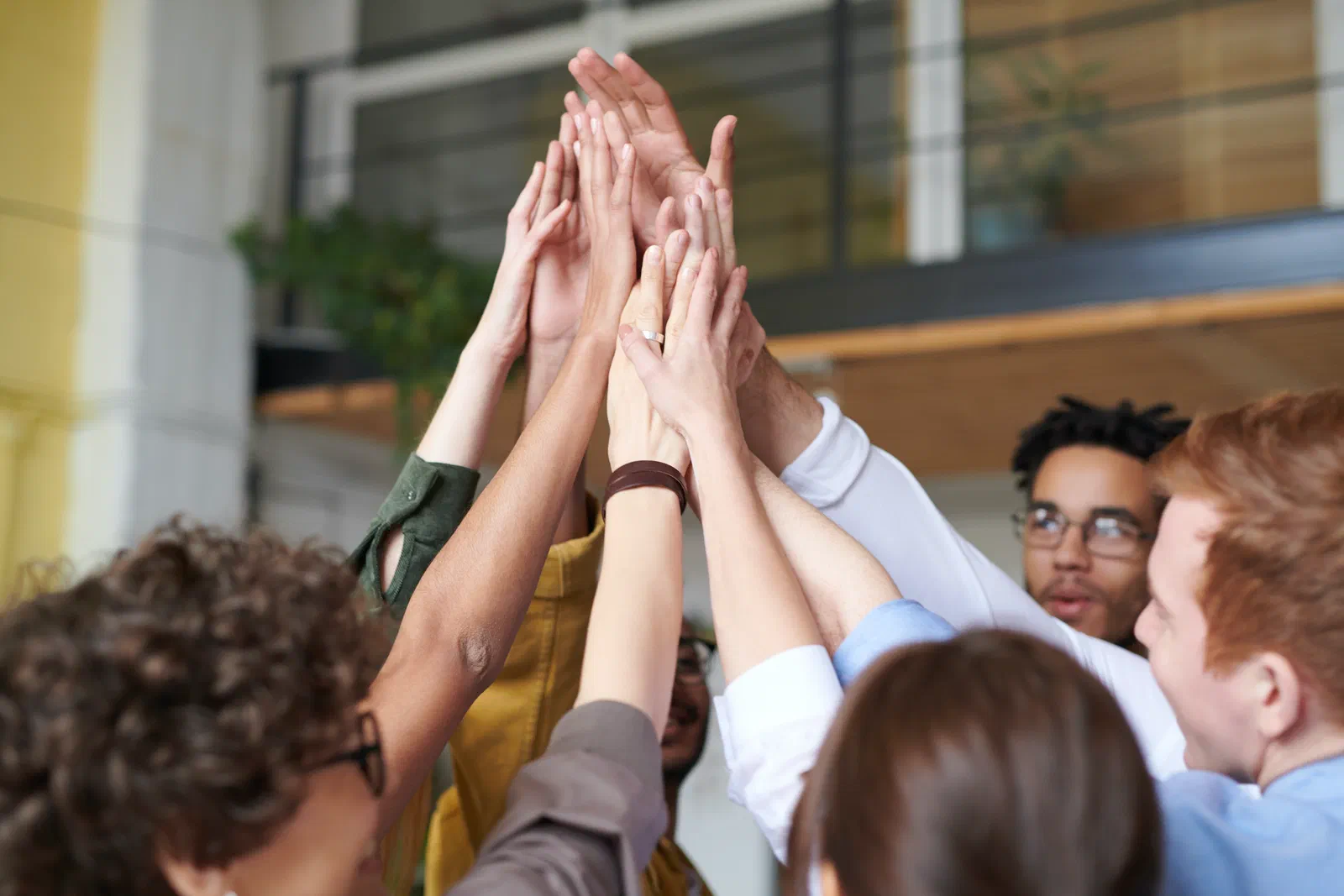 Photo Of People Touching Each Other’s Hands in the Air