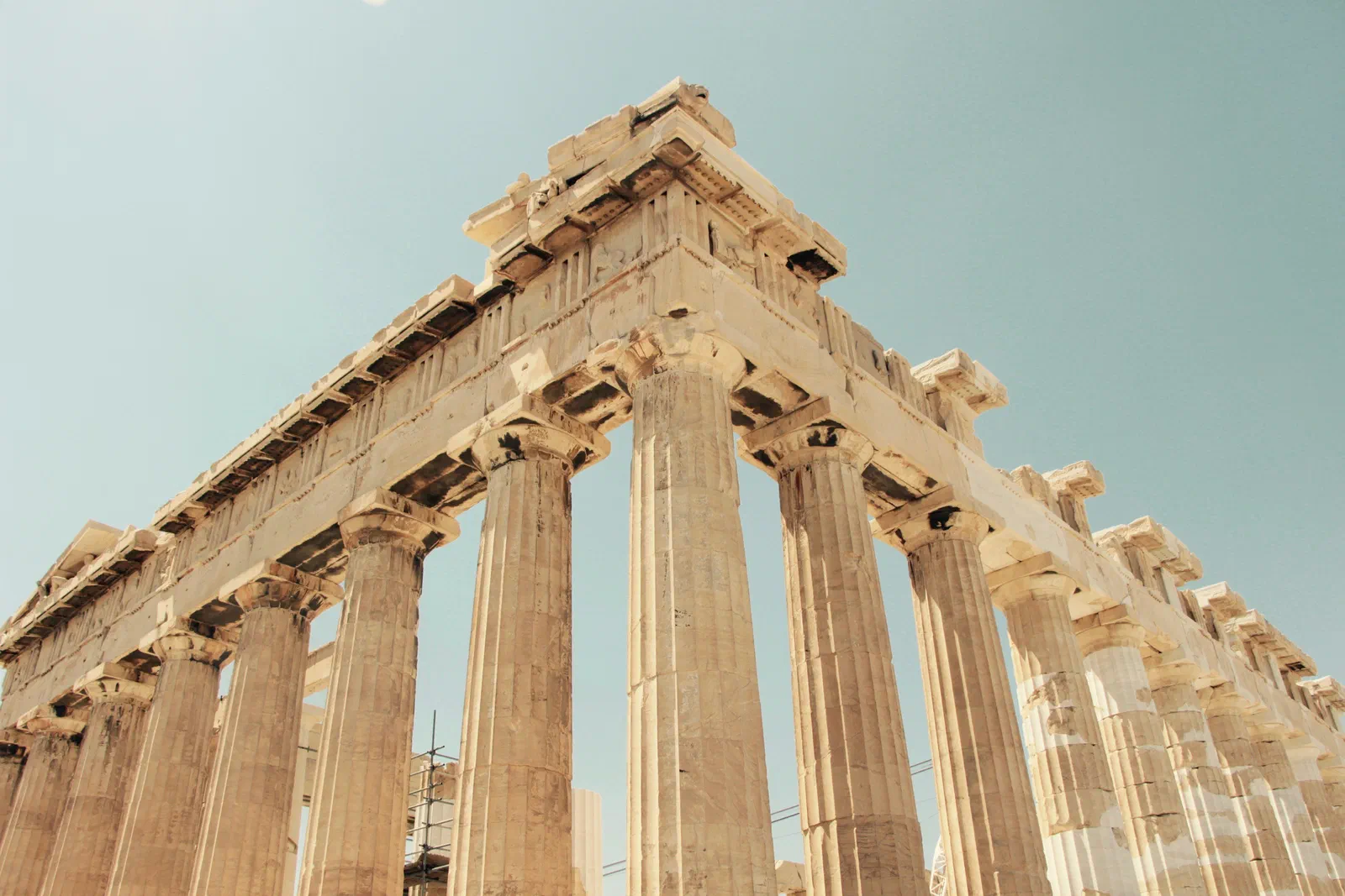 Low-angle view of the columns of the Parthenon in Athens against a pale sky